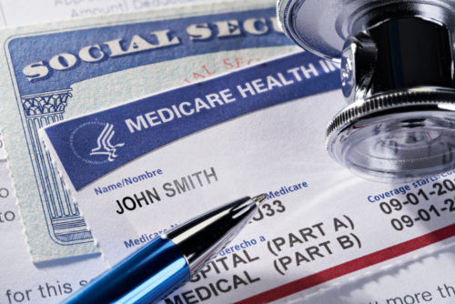 Medicare Health Insurance and Social Security Card on medical report and stethoscope